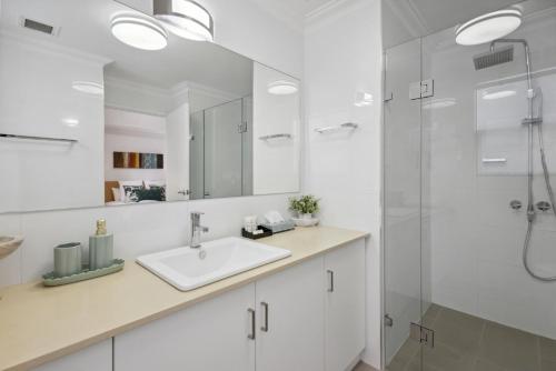 a white bathroom with a sink and a shower at 1BDR 1BTH 1PRK - James Street Joy in Perth