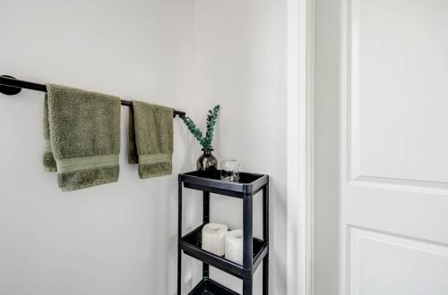 a black towel rack in a bathroom with towels at Urban Staycation In The Heart Of Downtown PTBO in Peterborough