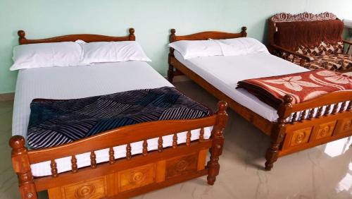 two beds sitting next to each other in a room at Green Mount Homestay in Vālpārai