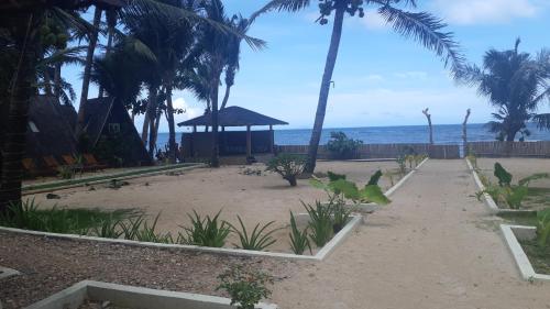 einen Strand mit einem Pavillon, Palmen und dem Meer in der Unterkunft Casa de Patrizia in Nabas