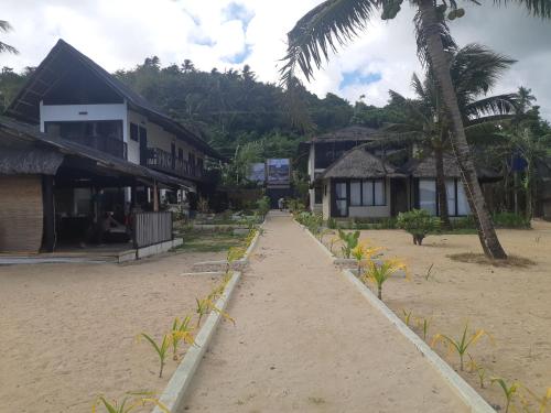 eine Straße, die zu einem Strand mit Häusern und Palmen führt in der Unterkunft Casa de Patrizia in Nabas