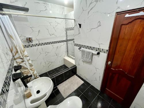 a bathroom with a white sink and a toilet at Suite amoblada - 4 min Consulado Americano in Guayaquil