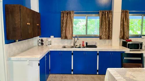 una cocina azul con fregadero y armarios azules en Ngermid Oasis - Vibrant 2 BD/1 BA Duplex, en Ngermid