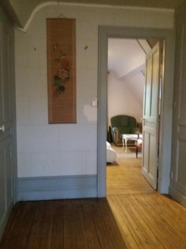 une chambre dotée d'un mur blanc et d'un tableau. dans l'établissement Les Roches, à Bolbec