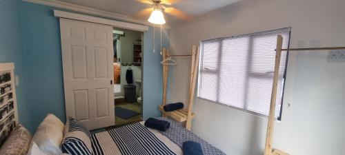 a room with a bed and a door and a window at Baggies Inn in Umkomaas