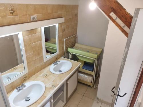 ein Badezimmer mit 2 Waschbecken und einem Spiegel in der Unterkunft Maison,Gite 8 places in Rivières