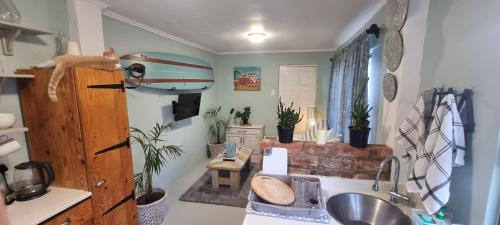 a kitchen with a sink and a surfboard on the wall at Baggies Inn in Umkomaas