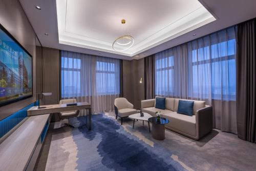 a living room with a couch and a table at Novotel Kunshan Yangcheng Lake in Kunshan