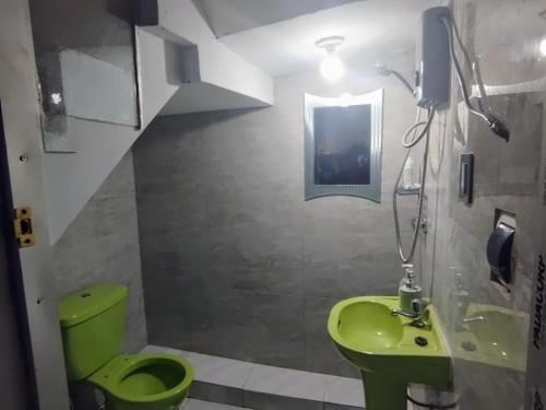 uma casa de banho com um WC verde e um lavatório em Hermosa casa em Huancayo