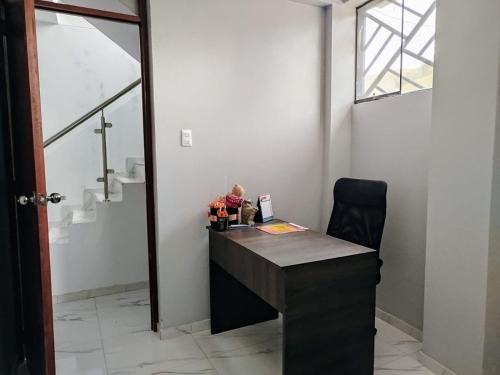 Habitación con ventana y escritorio con silla. en Hermosa casa, en Huancayo