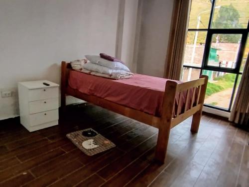 - un petit lit dans une chambre avec fenêtre dans l'établissement Hermosa casa, à Huancayo