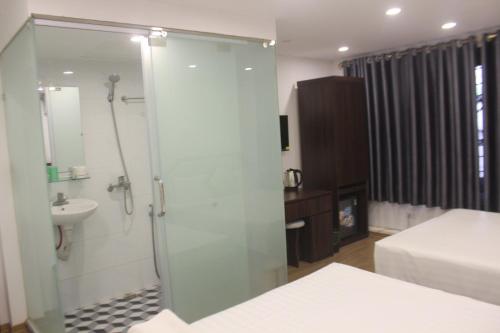 y baño con ducha, aseo y lavamanos. en Hanoi Little Hotel, en Hanói