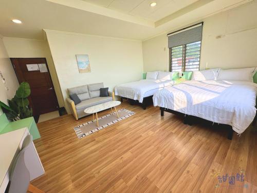 a room with two beds and a chair in it at Green Island Sweet Hotel in Green Island