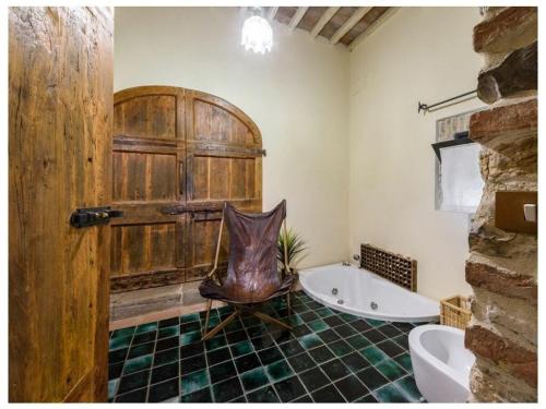 a bathroom with a large wooden door and a tub at Villa Fienile Design in SantʼAppiano