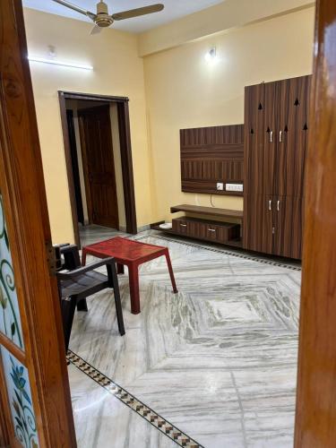 a room with a red table and a piano at VARAHA GUEST INN LUXURY ROOMs in Tirupati