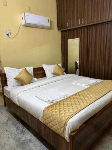 a bedroom with a large bed with white sheets at VARAHA GUEST INN LUXURY ROOMs in Tirupati