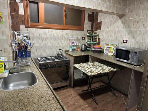 a small kitchen with a sink and a microwave at شقه عائليه قريبه من جميع الخدمات in Port Said
