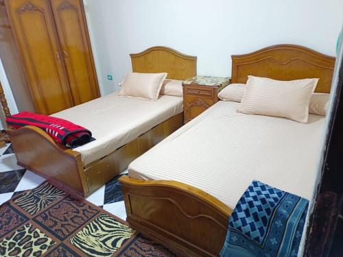 two beds sitting in a room with at شقه عائليه قريبه من جميع الخدمات in Port Said