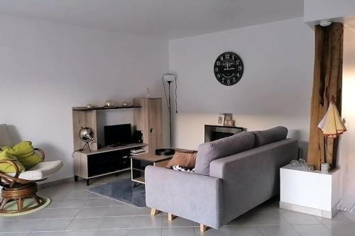 sala de estar con sofá y mesa en Le cocon rochois en Roches-sur-Marne