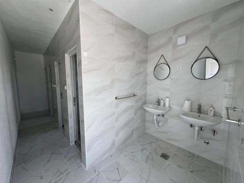 Baño blanco con 2 lavabos y espejo en Rural Tourism/Ruralni Turizam Kisin, en Trebinje