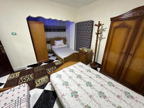 a small room with two beds and a wardrobe at شقه عائليه قريبه من جميع الخدمات in Port Said