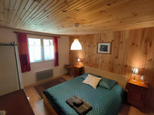 a bedroom with a bed in a room with wooden walls at La Ressource in Villars-Colmars