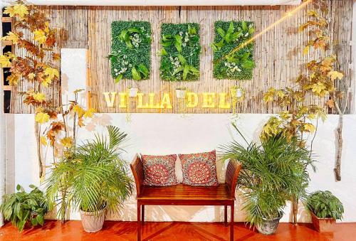 a bench with two pillows in a room with plants at The Lavana Villa Del Matabungkay by RedDoorz in Lian