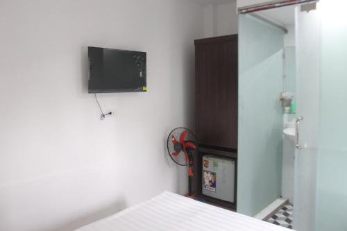 a room with a tv on the wall and a bed at Hanoi Little Hotel in Hanoi