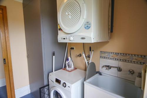 a laundry room with a washing machine and a fan at Seaside Shack in Encounter Bay