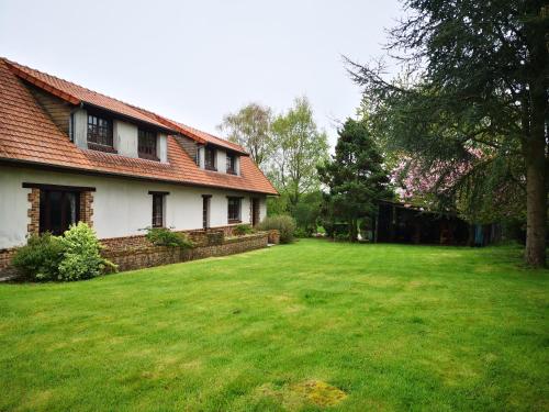a house with a large yard in front of it at Le cottage des quatre vents in Gouchaupré