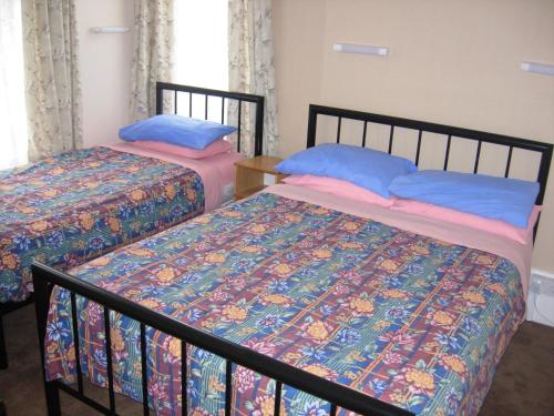 two beds sitting next to each other in a bedroom at Longfield Guest House in Dover
