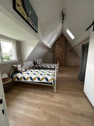 une chambre avec deux lits dans un grenier dans l'établissement Le cottage des quatre vents, à Gouchaupré