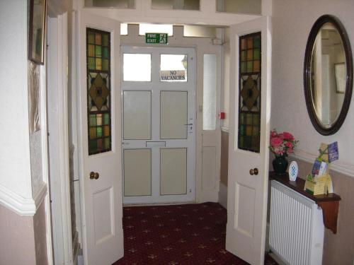a hallway with white doors and stained glass windows at Longfield Guest House in Dover