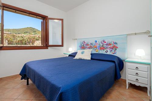 a bedroom with a blue bed and a window at New Villa Carmen in San Teodoro