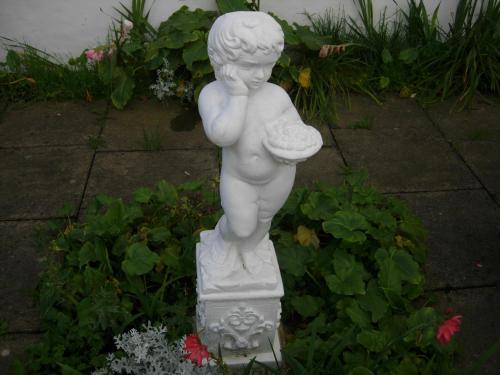 a white statue of a cherub standing in a garden at Longfield Guest House in Dover