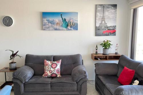 a living room with a gray couch and a picture at nuevo cómodo y amplio departamento 2 albercas in Xochitepec