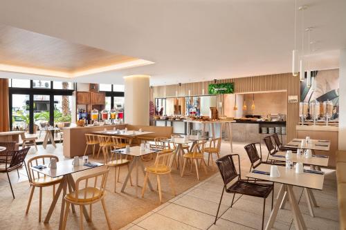 a restaurant with tables and chairs and a kitchen at Riviera Marriott Hotel La Porte De Monaco in Cap d'Ail