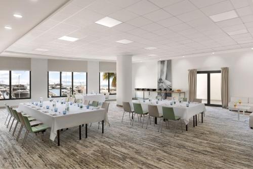a conference room with white tables and chairs and windows at Riviera Marriott Hotel La Porte De Monaco in Cap d'Ail