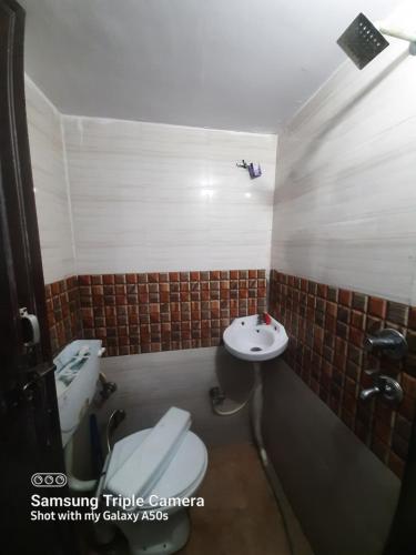 La petite salle de bains est pourvue de toilettes et d'un lavabo. dans l'établissement Gokul PG Homestay, à Gorakhpur