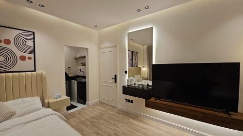 a bedroom with a large flat screen tv on the wall at شقه بغرفة نوم واحدة ودخول ذكي in Riyadh