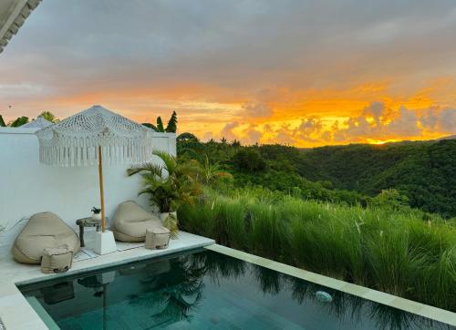 a villa with a swimming pool and a sunset at Atalaya Villas Nusa Penida - Adults only in Nusa Penida