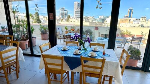 een eetkamer met een tafel en uitzicht op de stad bij Malta Crown guesthouse in St Julian's