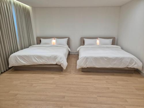twee bedden naast elkaar in een kamer bij Gwang Jang Hotel in Busan