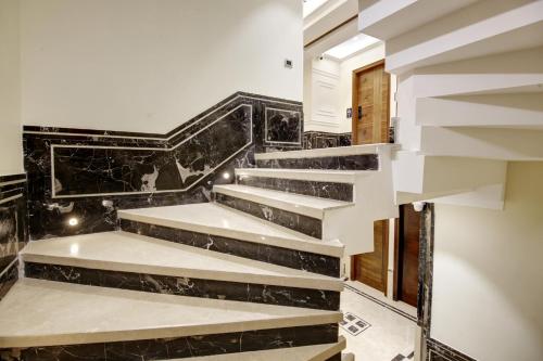 a staircase in a house with black marble at The Vanson Pride in New Delhi
