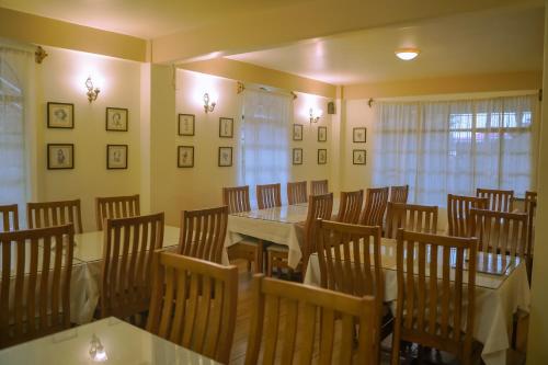 a dining room with a table and wooden chairs at MISSION VALLEY Kalimpong in Kalimpong