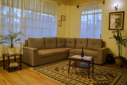 a living room with a couch and a table at MISSION VALLEY Kalimpong in Kalimpong
