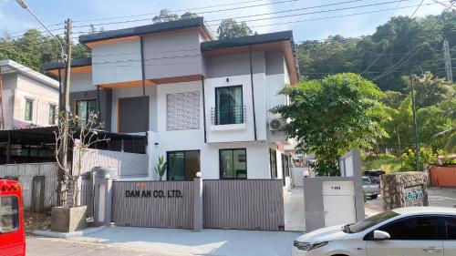 a white house with a fence in front of it at GREEN HILLS VILLAS - Dan An House in Patong Beach