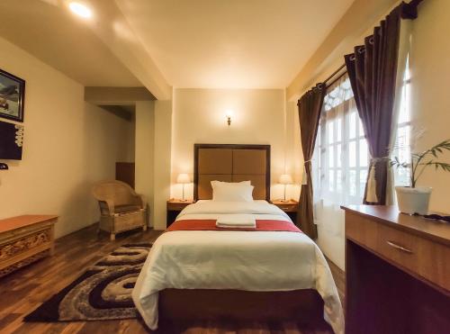a bedroom with a large bed and a window at MISSION VALLEY Kalimpong in Kalimpong