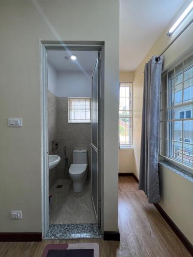 a bathroom with a toilet and a glass shower door at The Sparkling Turtle Backpackers Hostel in Kathmandu