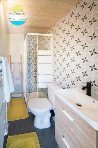 une salle de bain avec toilettes et lavabo dans l'établissement Le Nid des Calanques et son Jacuzzi, à Marseille